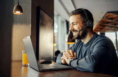 Notebook-Nutzer mit Headset als Symbolbild für Cloud Telefonie
