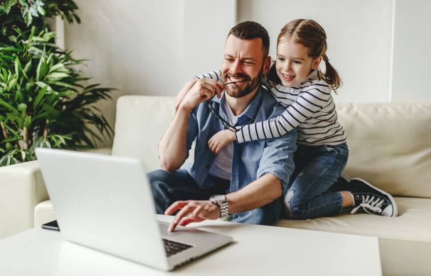 Vater und Tochter im Homeoffice vor einem Laptop