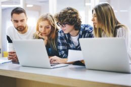 Schüler im Praktikum vor zwei Notebooks