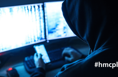 typisches Hackerbild, Person mit Kaputze vor Notebook zur optischen Versinnbildlichung eines Hacker