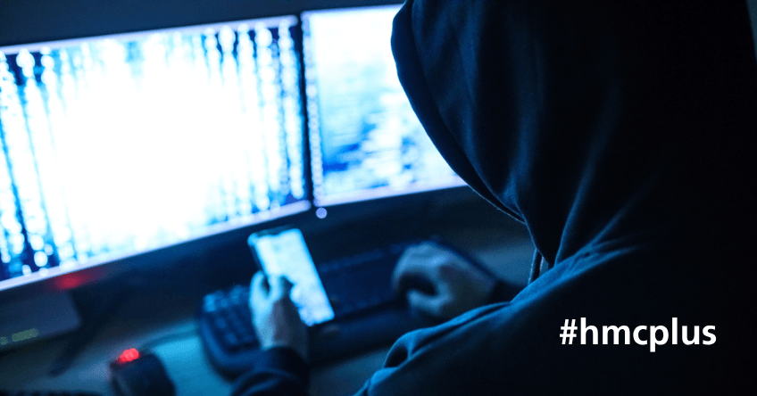 typisches Hackerbild, Person mit Kaputze vor Notebook zur optischen Versinnbildlichung eines Hacker